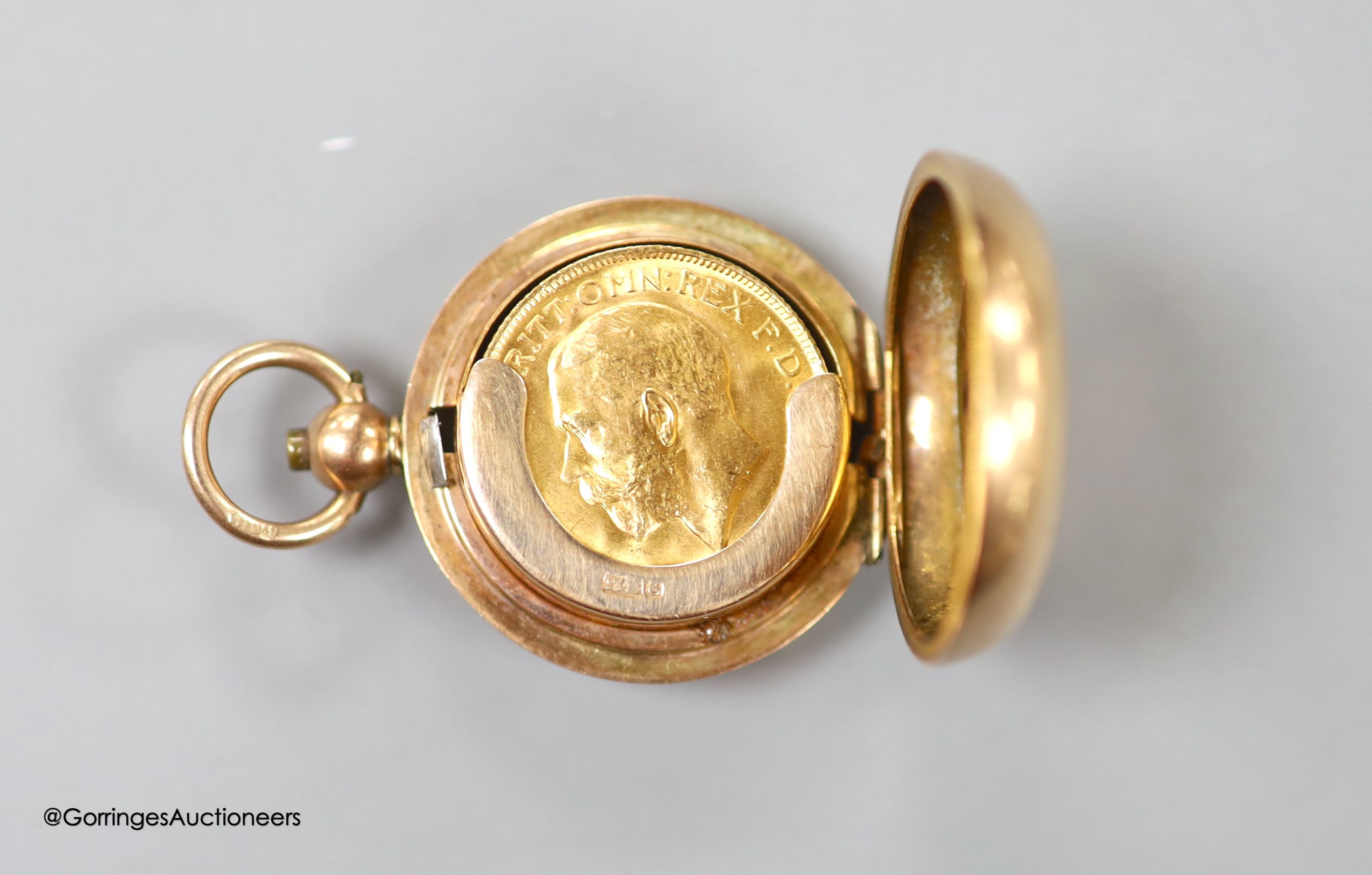A 9ct gold sovereign case, with engraved monogram, 30mm, gross weight 15.6 grams, containing a George V 1911 gold sovereign